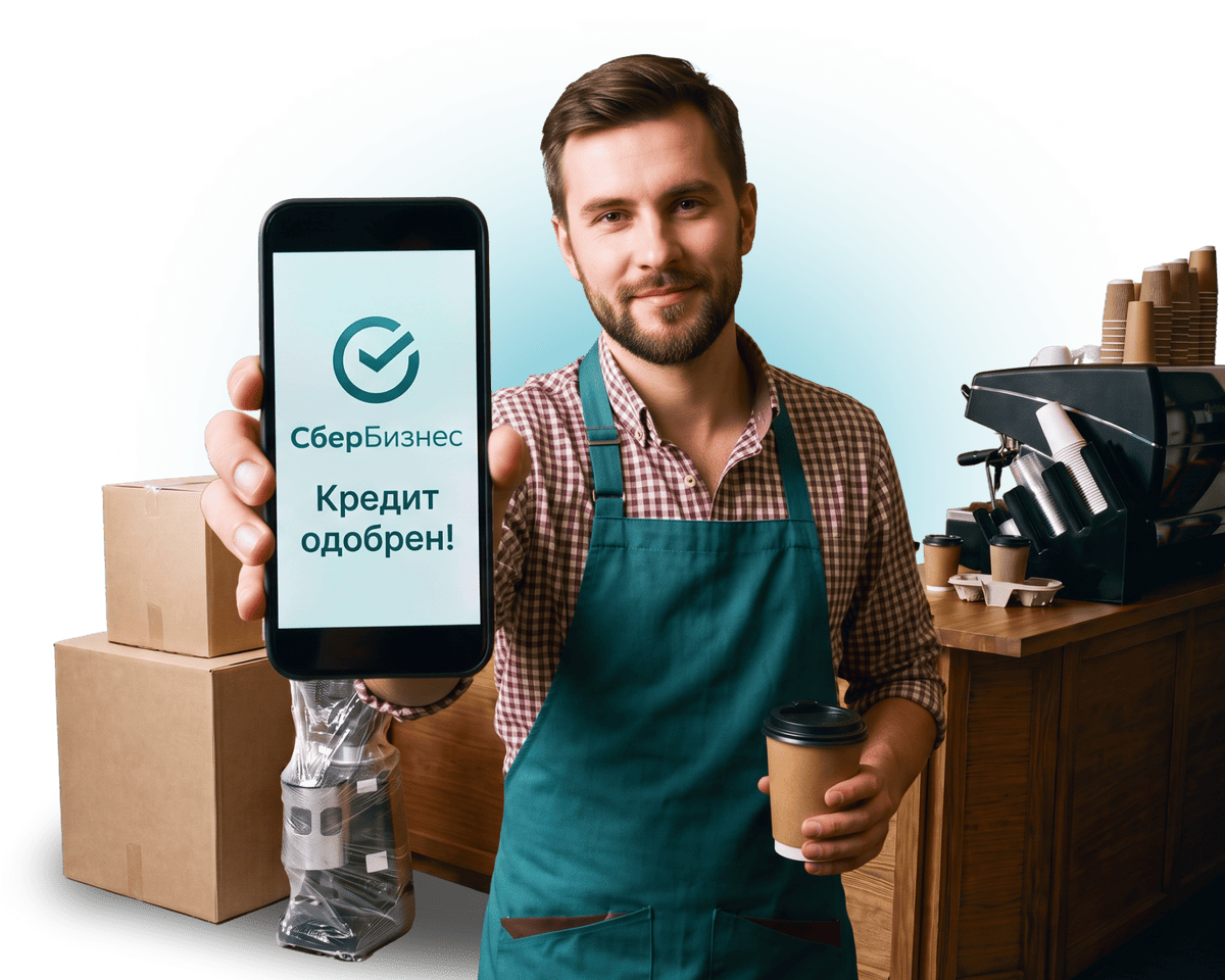 Предприниматель показывает смартфон с
уведомлением СберБизнес «Кредит одобрен!»